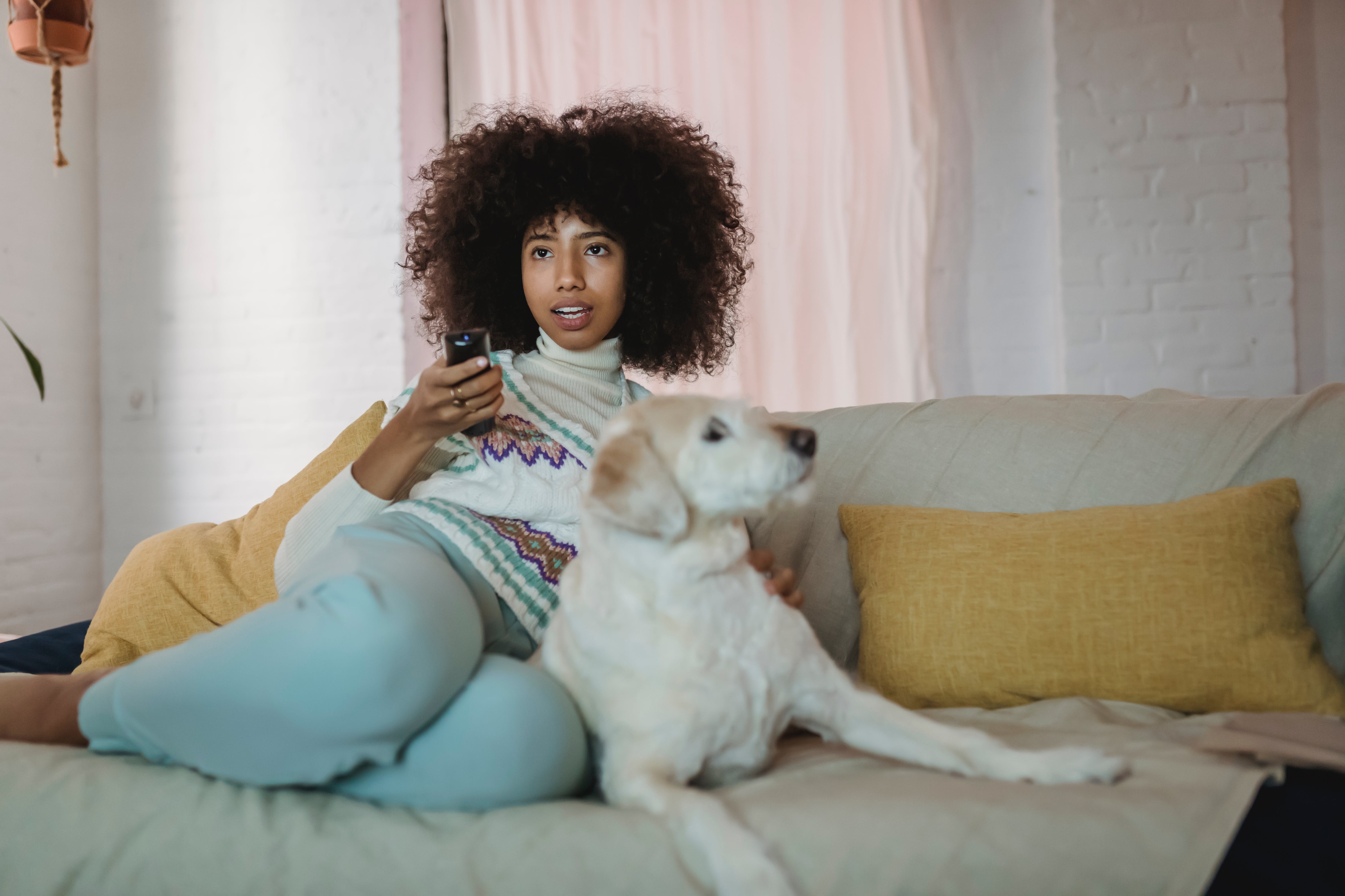 A woman is watching a movie at home with a dog | Source: Pexels
