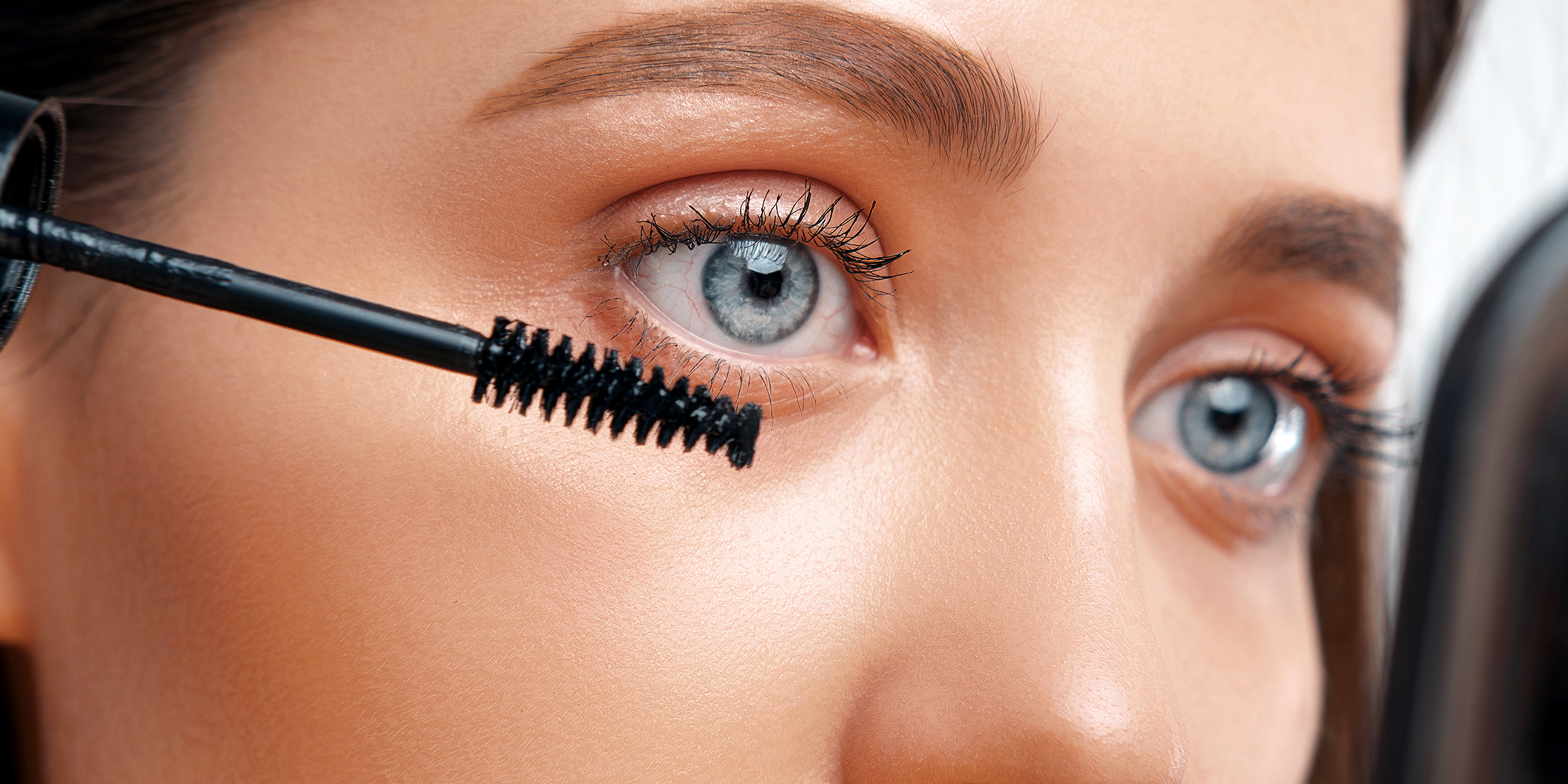 A woman applying a mascara | Source: Shutterstock